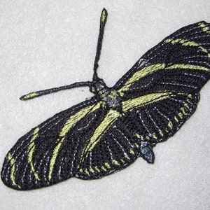 May include: Black and yellow embroidered butterfly patch. The butterfly has a detailed design with black wings and yellow stripes.