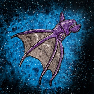 May include: A purple and gray embroidered octopus with eight tentacles against a dark blue starry background.