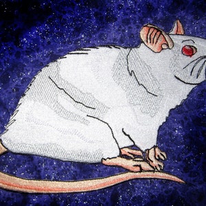 May include: White embroidered rat with red eyes on a dark blue background with white speckles.