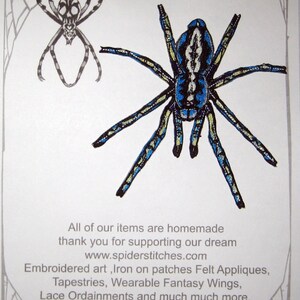 May include: Iron-on patch featuring a blue and black spider with yellow accents. The patch is for sale on the website spiderstitches.com. The text "Spider Stitches" is in the top left corner of the image. The text "Iron on Patch" is in the top right corner of the image. The text "www.spiderstitches.com" is below the text "Iron on Patch". The text "All of our items are homemade thank you for supporting our dream www.spiderstitches.com Embroidered art, Iron on patches Felt Appliques, Tapestries, Wearable Fantasy Wings, Lace Ordainments and much much more." is at the bottom of the image.