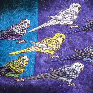 May include: Six colourful parakeets with different coloured feathers and beaks are embroidered on a purple and blue fabric background.