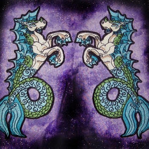 May include: Two embroidered seahorse designs with green, blue, and white details on a purple background with glitter.
