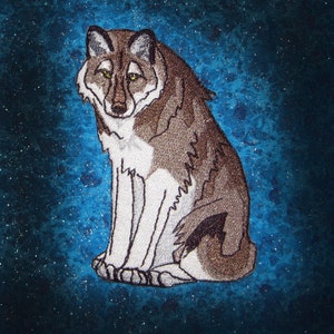 May include: A brown and white wolf with green eyes sits on a blue background with white speckles. The wolf is looking to the left of the image.