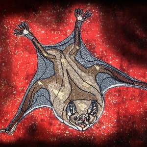 Puede incluir: Un murciélago bordado de color marrón y gris con las alas extendidas, colgado boca abajo sobre un fondo rojo brillante.