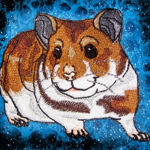 May include: Embroidered brown and white hamster with a smiling face against a blue and white galaxy background.