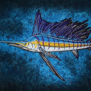 May include: A blue and yellow marlin fish with a long, pointed bill and a dorsal fin that is a dark purple colour. The fish is embroidered on a blue background.