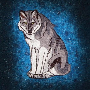 Könnte beinhalten: Ein grauer Wolf mit weißen Markierungen sitzt auf einem blauen Hintergrund mit weißen Flecken. Der Wolf hat eine schwarze Nase und gelbe Augen.