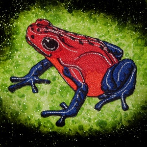 May include: Red and blue embroidered frog patch with a glittery green background.