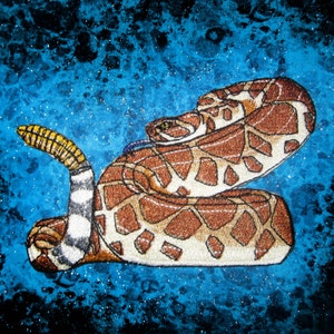 Puede incluir: Una serpiente de cascabel marrón y blanca con una cola amarilla enroscada sobre un fondo azul y negro.