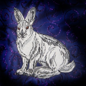May include: A white rabbit with red eyes is embroidered on a dark blue fabric with a purple swirl pattern.