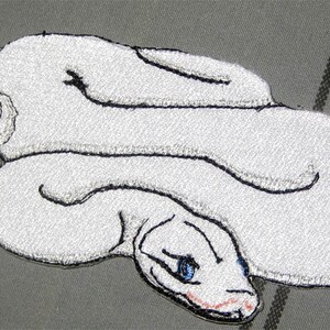 May include: White embroidered snake patch with blue eyes. The snake is curled up in a coil.