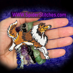 May include: An embroidered patch featuring a brown, white, and black collie dog in a running pose. The patch includes the text WWW.SpiderStitches.com. The design is detailed with stitched fur textures and distinct color blocking for the dog's coat.