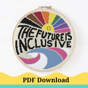 May include: A cross-stitch pattern featuring a rainbow with the text "The Future is Inclusive". The pattern is in a circular hoop.