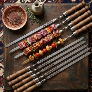 Puede incluir: Una taza de cerámica blanca con un asa negra y el texto "But First, Coffee" en negrita negra. La taza se encuentra sobre un fondo borroso, sugiriendo un ambiente acogedor.