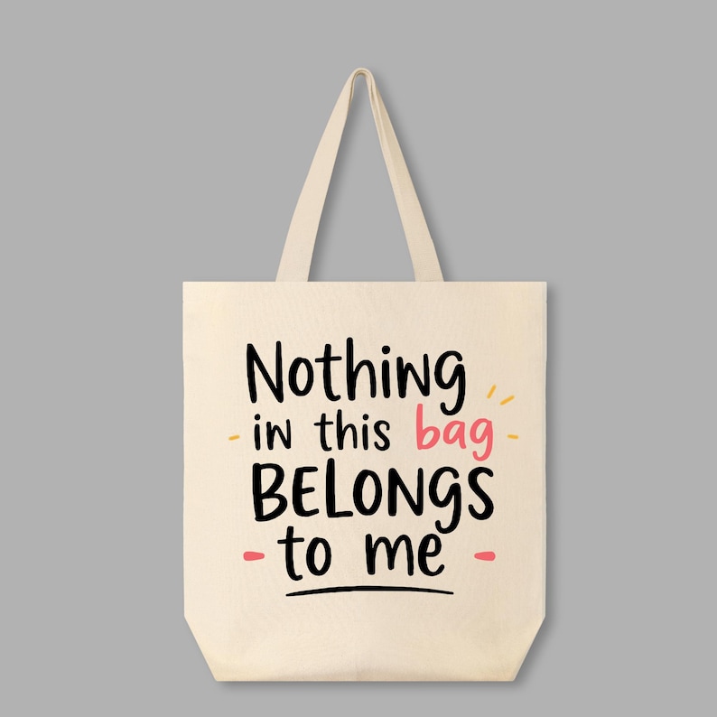 May include: A white canvas tote bag with the text "Nothing in this bag BELONGS to me" in black and pink lettering.