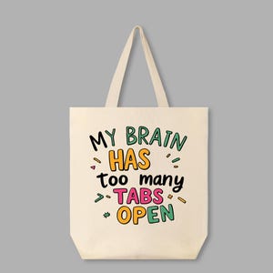May include: A white canvas tote bag with the text "My brain has too many tabs open" in colorful, handwritten lettering.