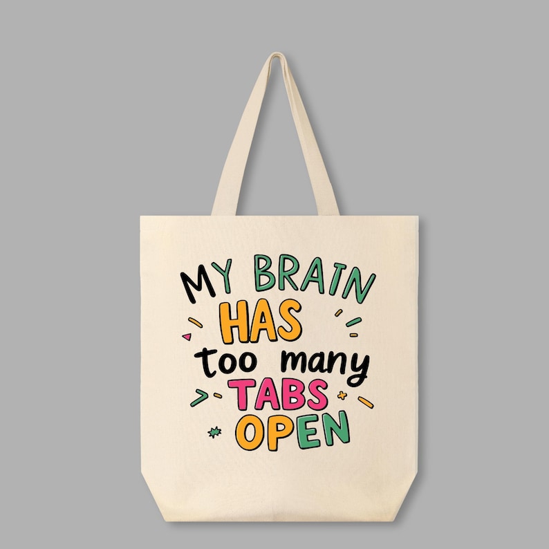 May include: A white canvas tote bag with the text "My brain has too many tabs open" in colorful, handwritten lettering.