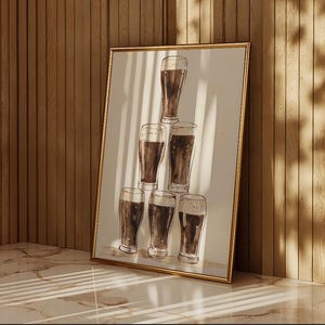 May include: A framed print featuring a watercolor illustration of six beer glasses arranged in a pyramid. The glasses are filled with dark beer, and the artwork has a gold frame. The background is a neutral white.