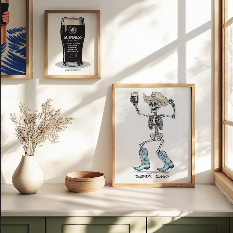 May include: Framed art prints featuring a pint of Guinness and a skeleton cowboy holding a pint. The skeleton wears a cowboy hat and blue boots. The text "Guinness Cowboy" is below the image. The other print shows a pint of Guinness.
