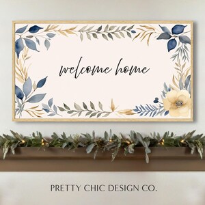 Puede incluir: Una impresión acuarela enmarcada con fondo blanco y un borde floral azul y dorado. El texto "welcome home" está escrito en letra negra en el centro de la impresión.
