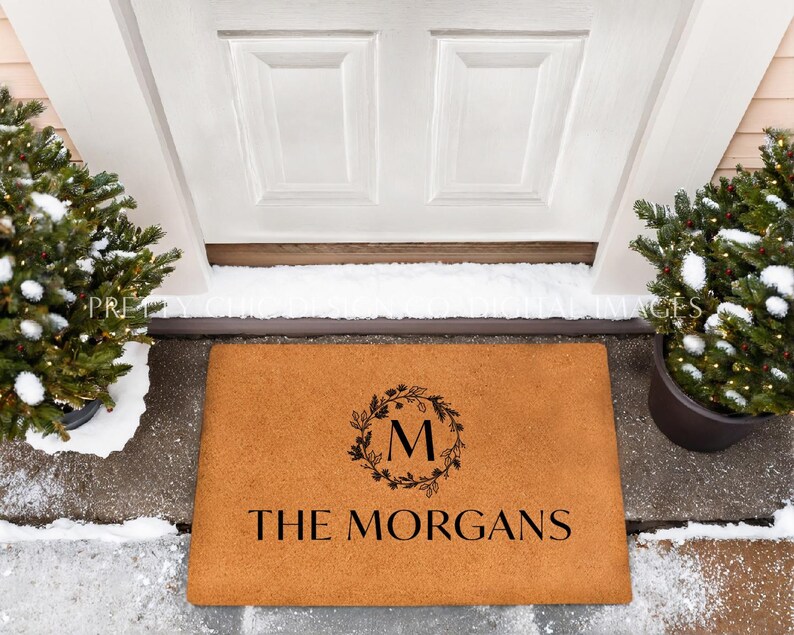 May include: A brown coir doormat with the text "The Morgans" and a wreath with the letter "M" in the center.