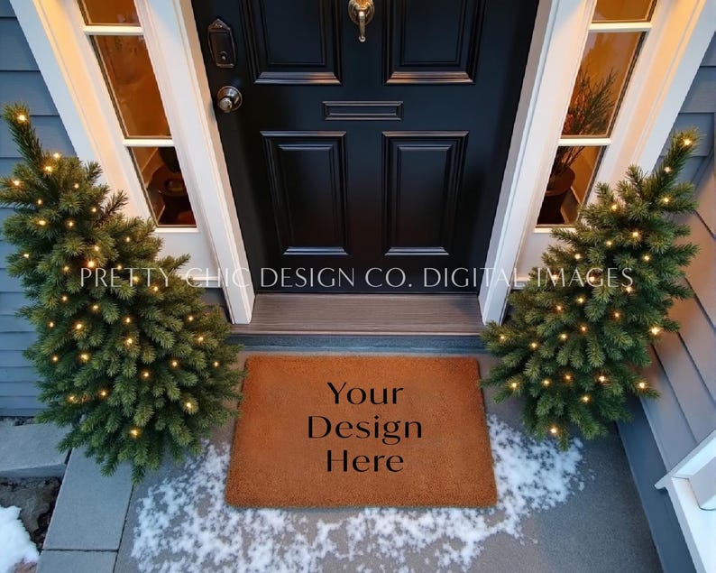May include: A brown coir doormat with the text "Your Design Here" on it. The doormat is placed in front of a black door with a glass window on either side. There are two small Christmas trees with white lights on either side of the doormat.