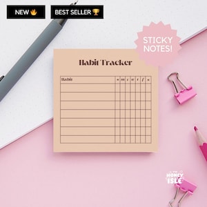 May include: A peach-colored sticky note with the text "Habit Tracker" printed in brown. The note is divided into columns labeled "Habit" and "S M T W T F S".