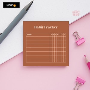 May include: A brown habit tracker sticky note with the text "Habit Tracker" in white. The note has a grid with the days of the week labeled "S M T W T F S".