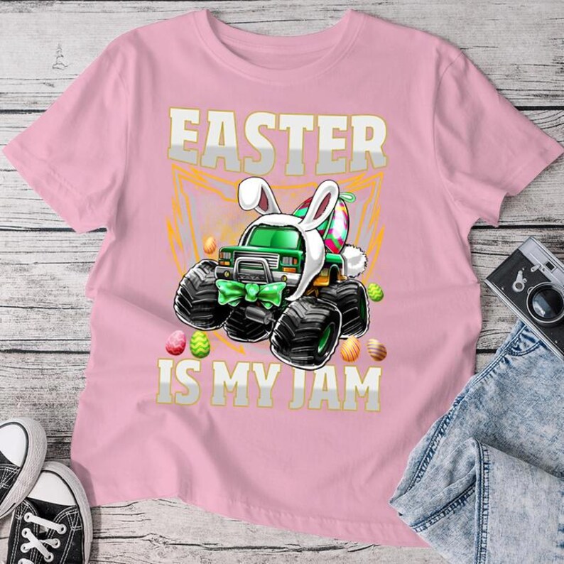 May include: Pink t-shirt with a green monster truck wearing bunny ears and the text "Easter is my jam".