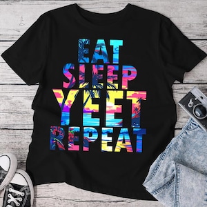 May include: Black t-shirt with a colorful graphic print that reads "Eat Sleep Yeet Repeat" with palm trees and a sunset in the background.