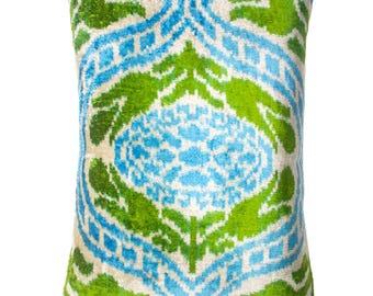 May include: Decorative square pillow with a vibrant floral pattern in shades of blue and green on a cream background. The pillow has a soft, velvety texture and a classic design, perfect for adding a pop of color to any room.