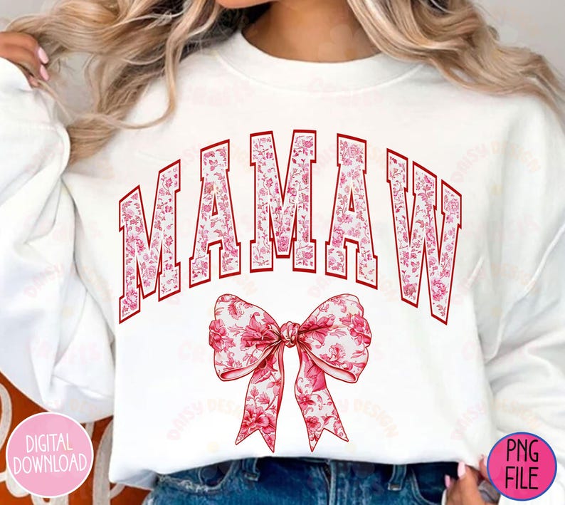 May include: White sweatshirt with the text "MAMAW" in red letters with a pink floral pattern. The letters are outlined in red and have a vintage collegiate style. A pink floral bow is below the text.