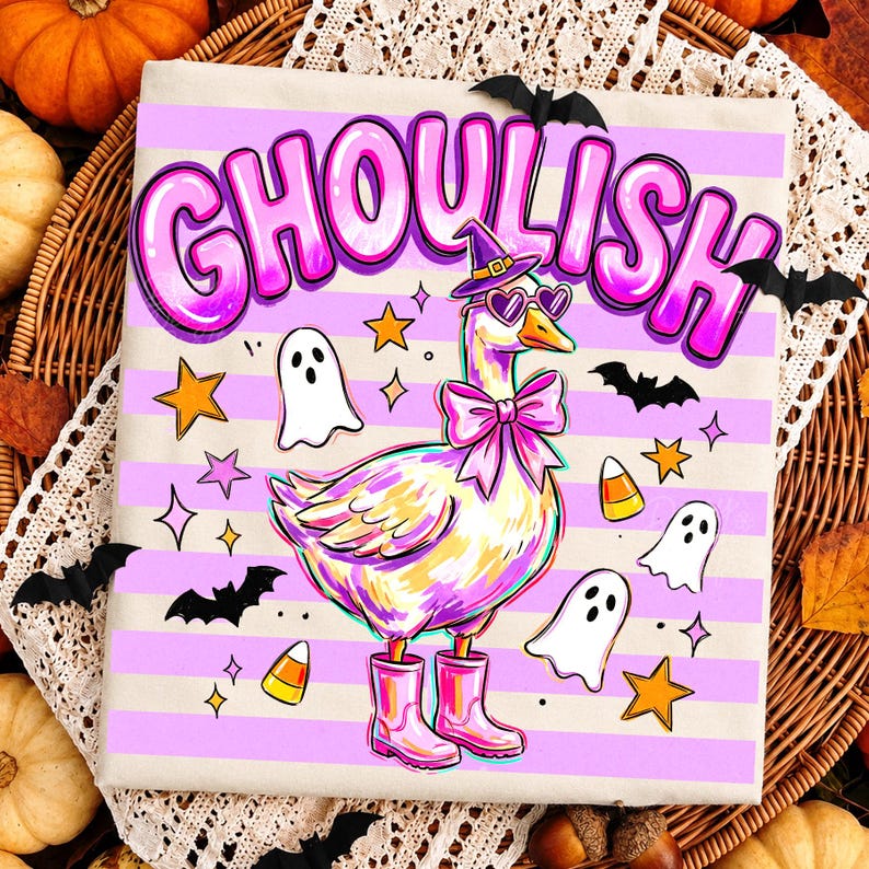 May include: A light-colored fabric featuring a horizontal striped pattern in light purple and white. The design displays a goose wearing a purple witch hat, heart-shaped sunglasses, and a pink bow, with pink boots. Text reads GHOULISH.