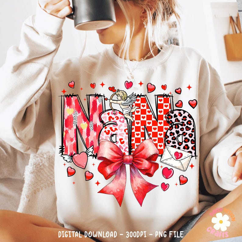 May include: A white sweatshirt with a red, pink, and black graphic design that says "Nana" with a cupid and a bow. The design is surrounded by red hearts.