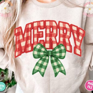 May include: A light beige sweatshirt with the word "MERRY" in red and white plaid lettering. A green and white plaid bow is below the word "MERRY". The words "DIGITAL FILE" and "PNG FILE" are in the bottom corners.