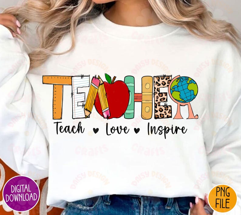 K&ouml;nnte beinhalten: Wei&szlig;er Pullover mit einem Grafikdesign, das "Teacher" in bunten Buchstaben sagt. Die Buchstaben bestehen aus verschiedenen Schulmaterialien, darunter Bleistifte, ein Lineal, ein Buch und ein Globus. Der Text "Teach Love Inspire" befindet sich unter der Grafik.