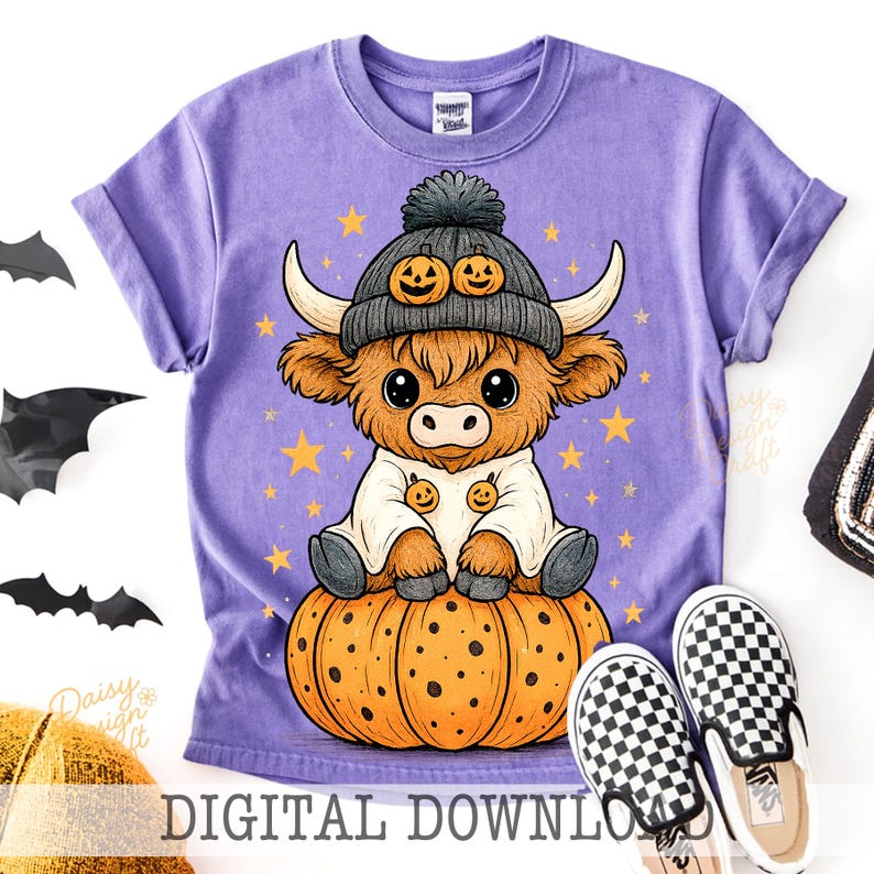 Op de afbeelding: Een paars T-shirt met een cartoon Highland-koe met een pompoenhoed en zittend op een pompoen. Het ontwerp bevat sterren en de tekst "DIGITAL DOWNLOAD". Een paar zwart-wit geruite instappers liggen ernaast.
