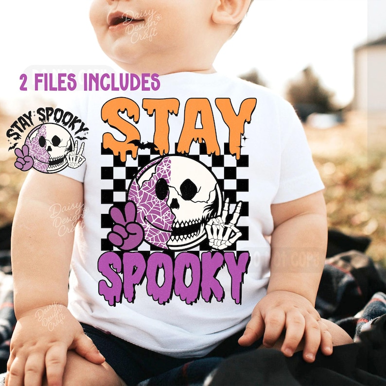 May include: White t-shirt with a Halloween graphic. The design includes the words "STAY SPOOKY" in orange and purple, a skull with a peace sign, and a checkerboard pattern. The words "2 FILES INCLUDES" are also visible.