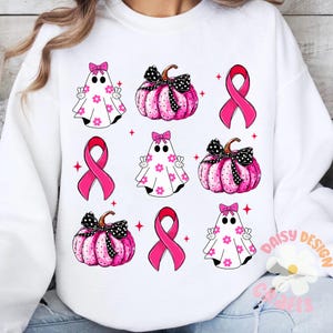 May include: White sweatshirt with a pink and black pattern of ghosts, pumpkins, and pink ribbons. The design is repeated throughout the sweatshirt.