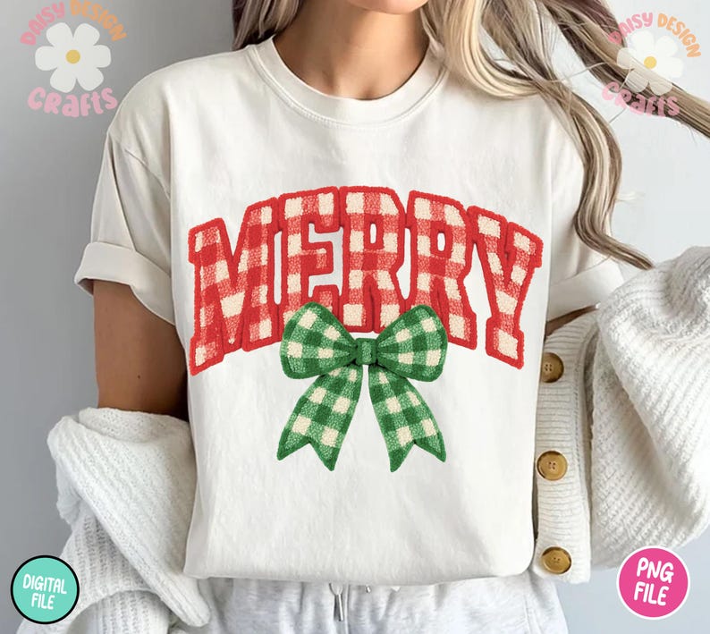 May include: White t-shirt featuring the word "MERRY" in red and white gingham print, with a green and white gingham bow. The shirt is a casual style, perfect for the holiday season.