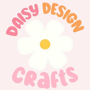 May include: A graphic logo featuring a white daisy flower with a yellow center. The word DAISY is written in pink above the flower, the word DESIGN is written in orange to the right, and the word CRAFTS is written in pink below the flower.