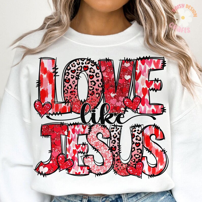 May include: White sweatshirt with a red, pink and black graphic print that says "Love like Jesus". The graphic features hearts, leopard print and glitter.