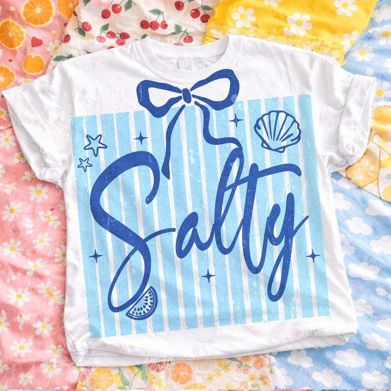 May include: White t-shirt with a blue bow, blue and white striped background, and the word "Salty" in a script font. The design includes a seashell, stars, and a watermelon slice.