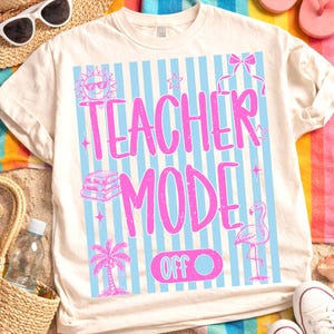 Puede incluir: Camiseta color crema con un diseño rosa y azul. El diseño presenta las palabras "TEACHER MODE" en rosa, sobre rayas azules y blancas. Gráficos adicionales incluyen un sol, estrellas, libros, una palmera, un flamenco y la palabra "OFF".