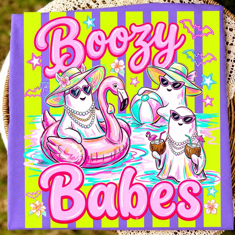 May include: A purple and lime green striped t-shirt featuring three white ghosts wearing sunglasses and hats. The text reads Boozy Babes. One ghost floats in a pink flamingo pool float, another holds a beach ball, and the third holds coconut drinks.