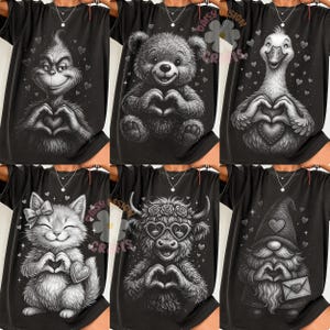 May include: Black t-shirts featuring various grayscale illustrations of characters making heart shapes with their hands. Designs include a Grinch, teddy bear, goose, cat, cow, and gnome. Each design has heart accents.
