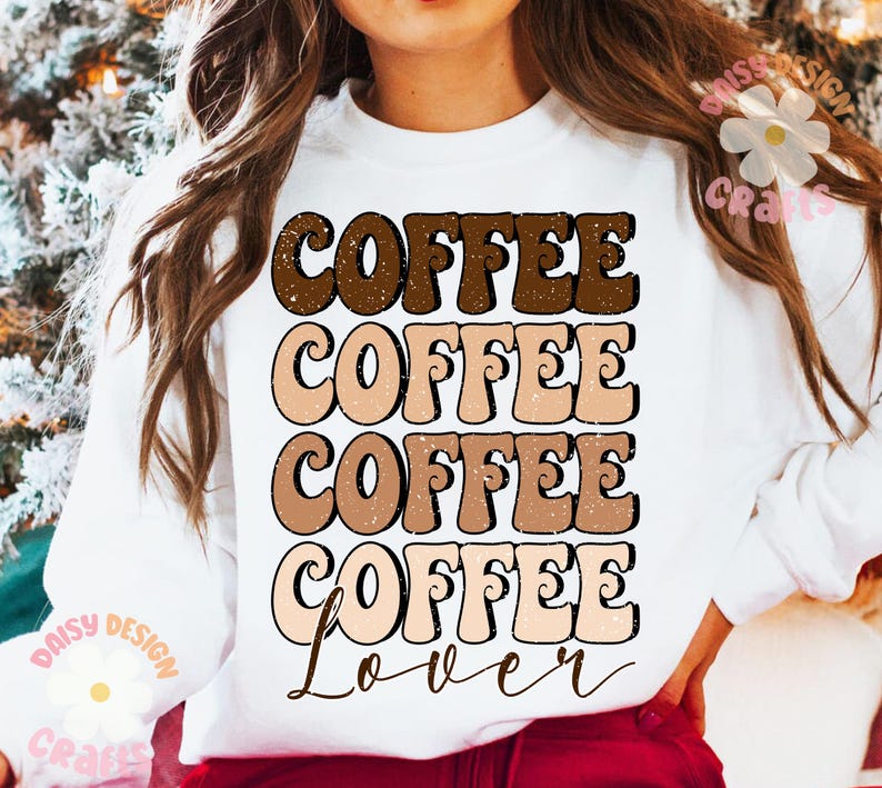 Puede incluir: Sudadera blanca con un dise&ntilde;o gr&aacute;fico que dice "Coffee Coffee Coffee Coffee Lover" en una fuente retro con colores marr&oacute;n, tostado y melocot&oacute;n.