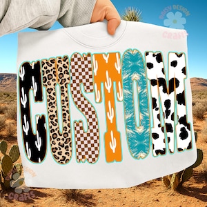 May include: White sweatshirt with the word "CUSTOM" in a variety of patterns and colors. The letters are black with white cacti, leopard print, brown checkered, orange with white cacti, turquoise, and black and white cow print.