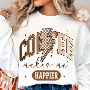 Puede incluir: Sudadera blanca con un gr&aacute;fico de rayo de ajedrez marr&oacute;n y blanco y el texto "COFFEE makes me HAPPIER".