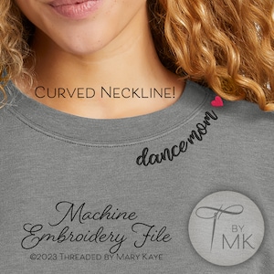 May include: Gray sweatshirt with a curved neckline and black embroidery that reads "dance mom" with a small pink heart above the text. The text "Machine Embroidery File" is written in cursive below the image. The text "©2023 THREADED BY MARY KAYE" is written below the cursive text. The text "BY MK" is written in a circle with a needle and thread design.